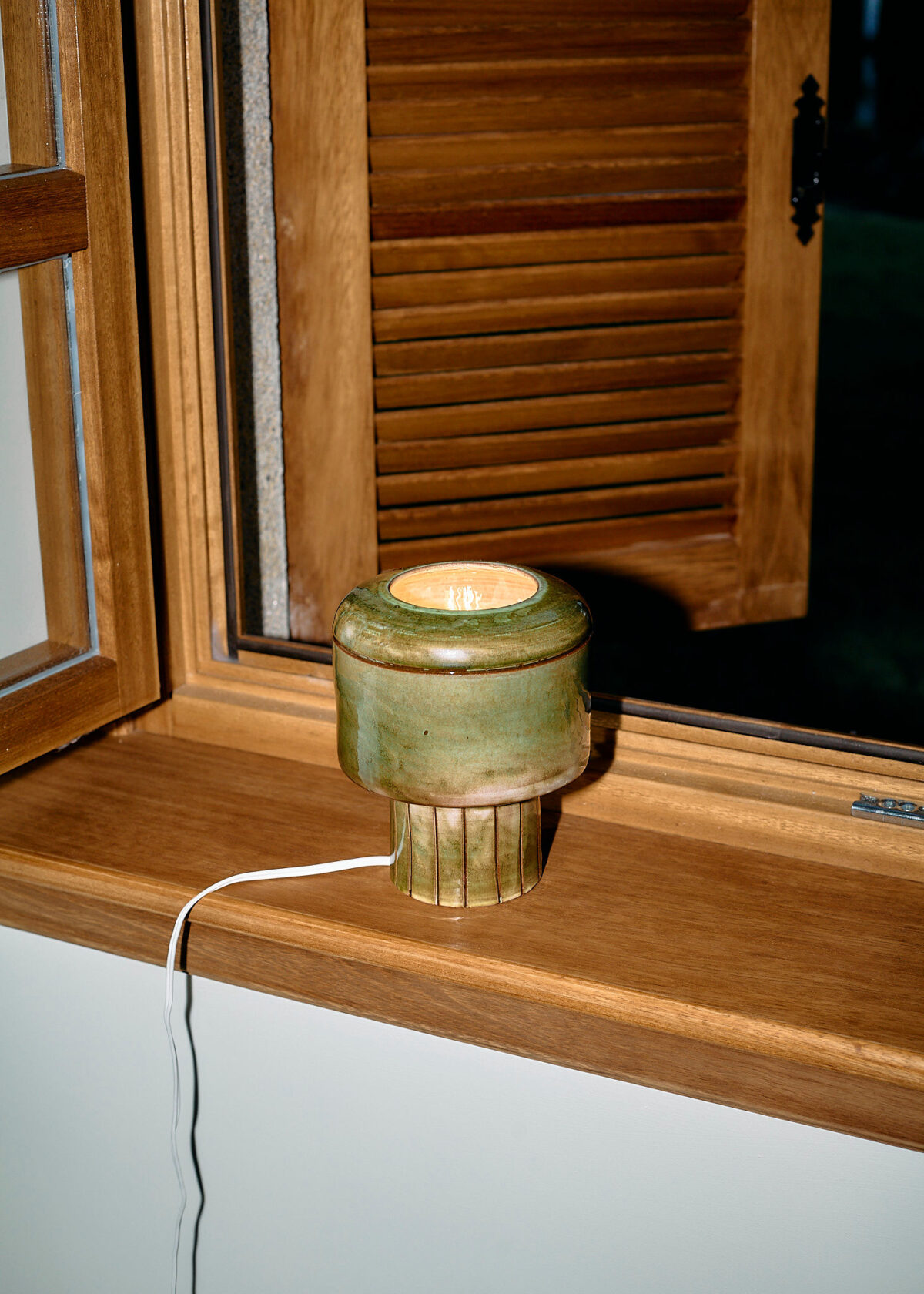 Ceramic lamp on wooden windowsill produced in Europe